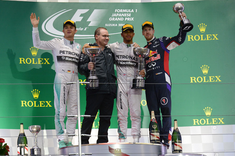 Lewis Hamilton, Nico Rosberg and Sebastian Vettel acknowledge the crowd during a sombre podium ceremony 
