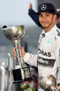 Lewis Hamilton poses with his winners' trophy on the podium