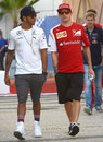 Lewis Hamilton and Kimi Raikkonen talk in the paddock on Saturday morning