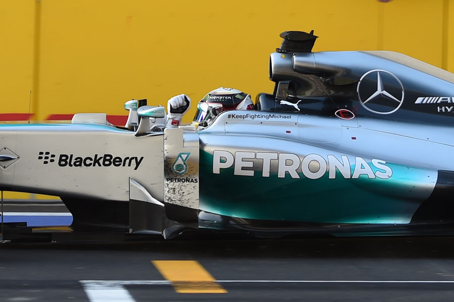 Lewis Hamilton pumps his first in celebration as he crosses the line