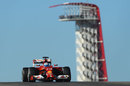 Fernando Alonso crests a hill with the COTA tower in the background