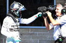 Nico Rosberg celebrates with a cameraman in parc ferme after taking pole position