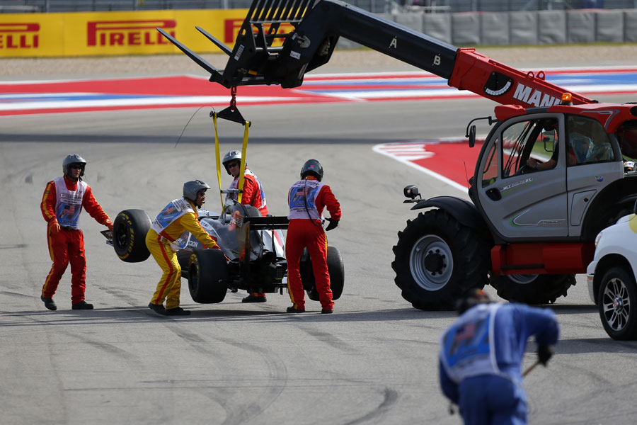 Adrian Sutil's car is lifted away after his first-lap collision with Sergio Perez