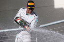 Race-winner Lewis Hamilton sprays champagne from the podium