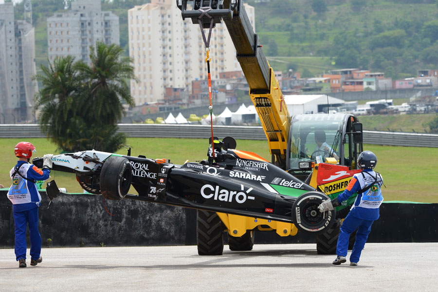 Dani Juncadella's Force India is lifted from the track after crashing in FP1