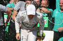 Nico Rosberg ducks from spray as he celebrates victory with Mercedes in the paddock