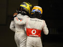 Nico Rosberg is congratulated on his maiden victory by McLaren's Lewis Hamilton
