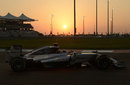 The sun sets in the background as Lewis Hamilton drives in FP2