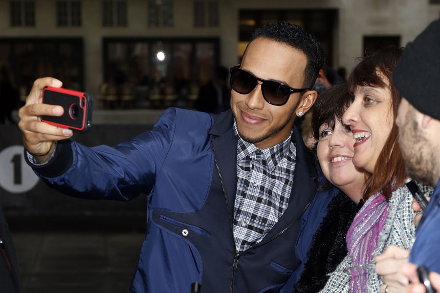 Lewis Hamilton poses for a selfie with fans outside BBC headquarters