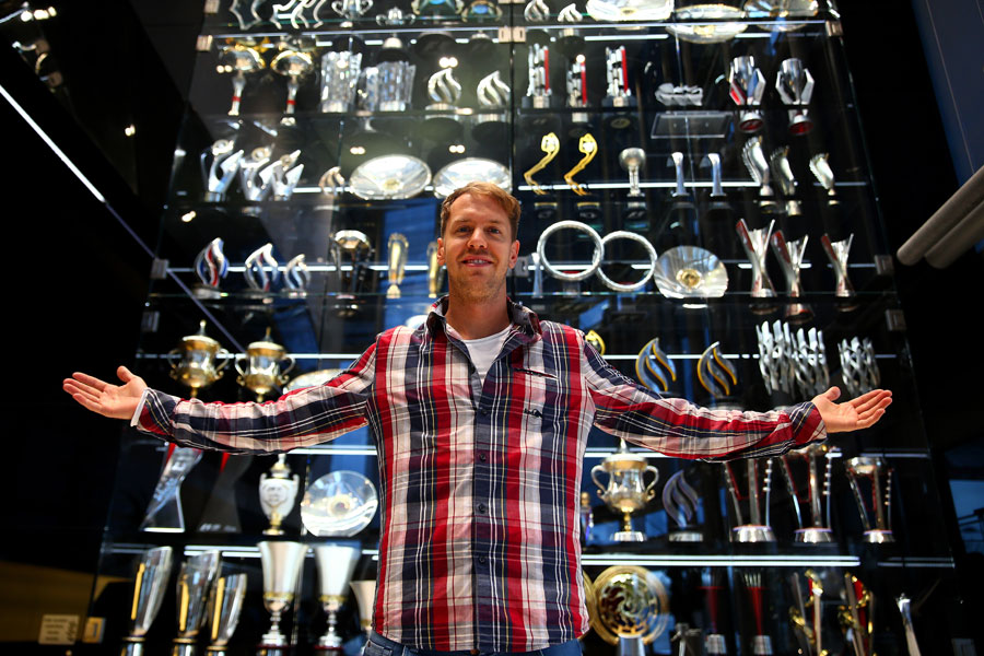Sebastian Vettel poses in front of Red Bull's trophy cabinet during a farewell visit to the team's Milton Keynes factory