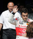 Fernando Alonso celebrates pole under the awkward gaze of McLaren boss Ron Dennis after the Spaniard held up Lewis Hamilton in qualifying