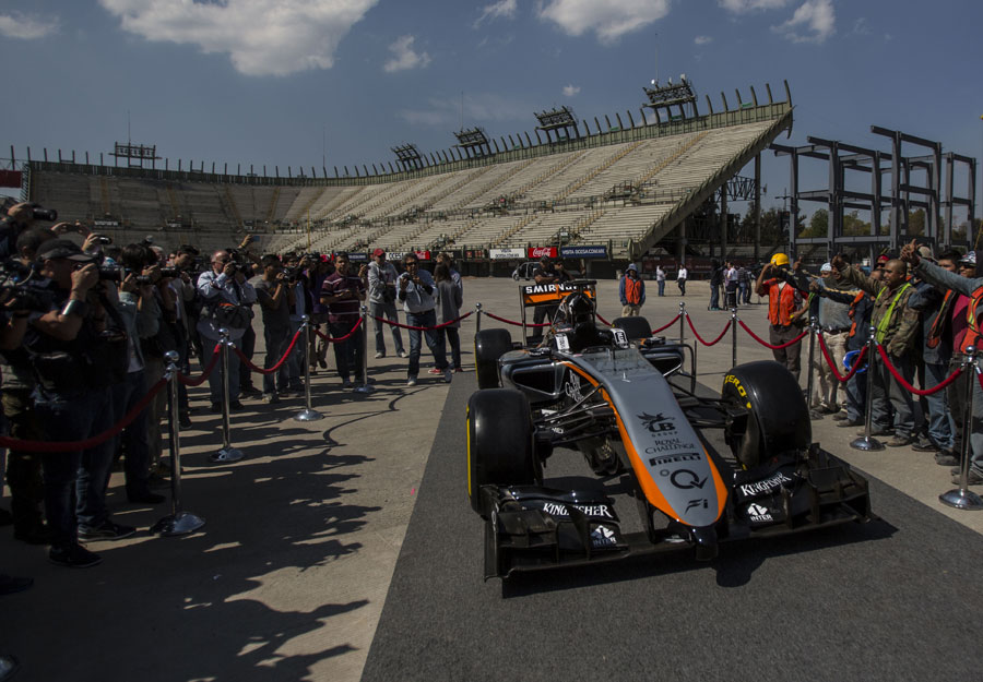 The new livery of the Force India is photographed in front of an unfinished stand at Hermanos Rodriguez Racing Circuit