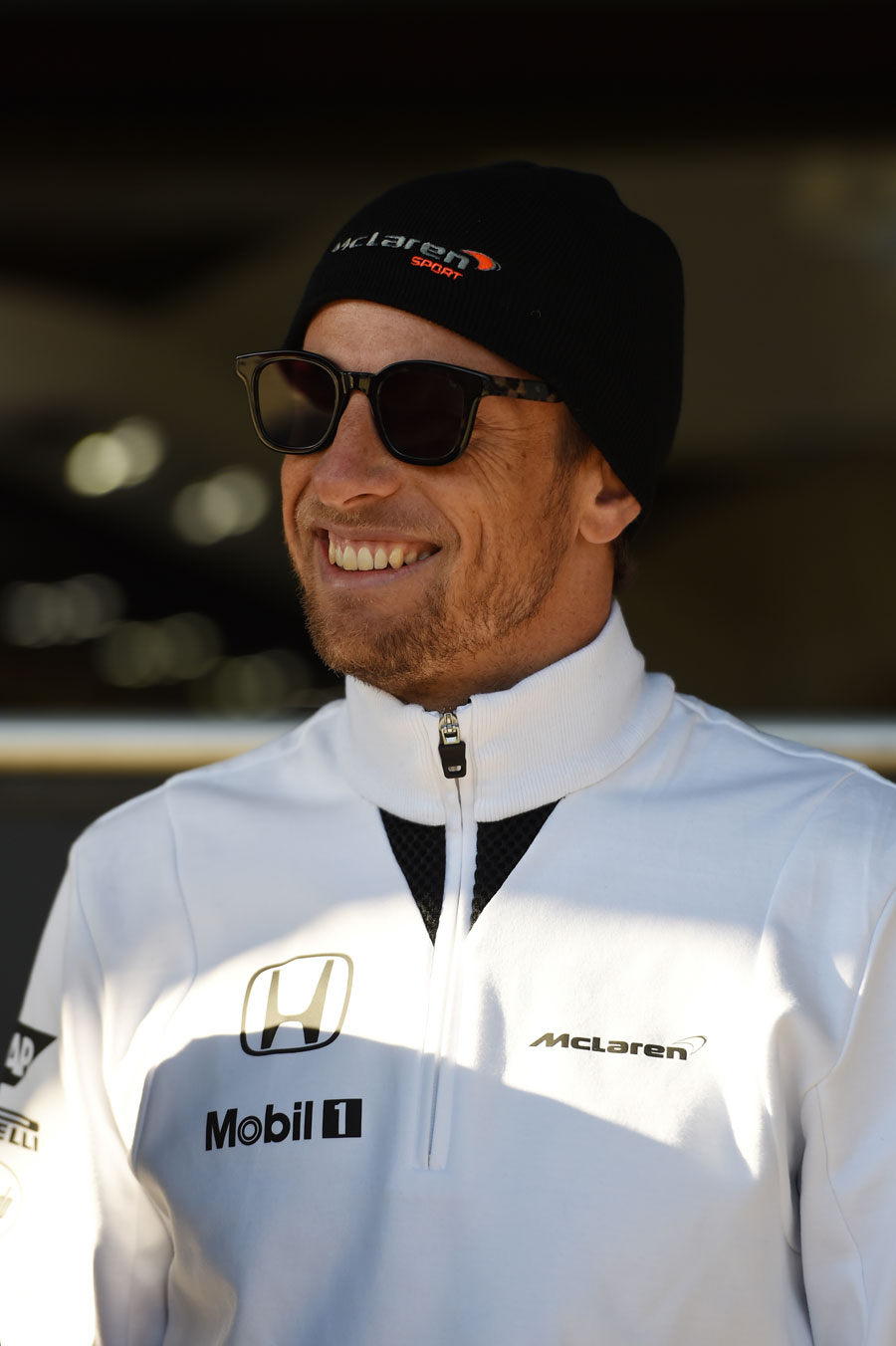McLaren's Jenson Button watches proceedings from the paddock on Sunday morning