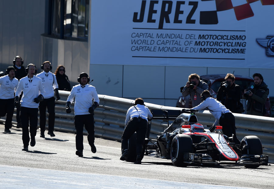 McLaren mechanics rush to Jenson Button's MP4-30 after it came to a half at the end of the pit lane