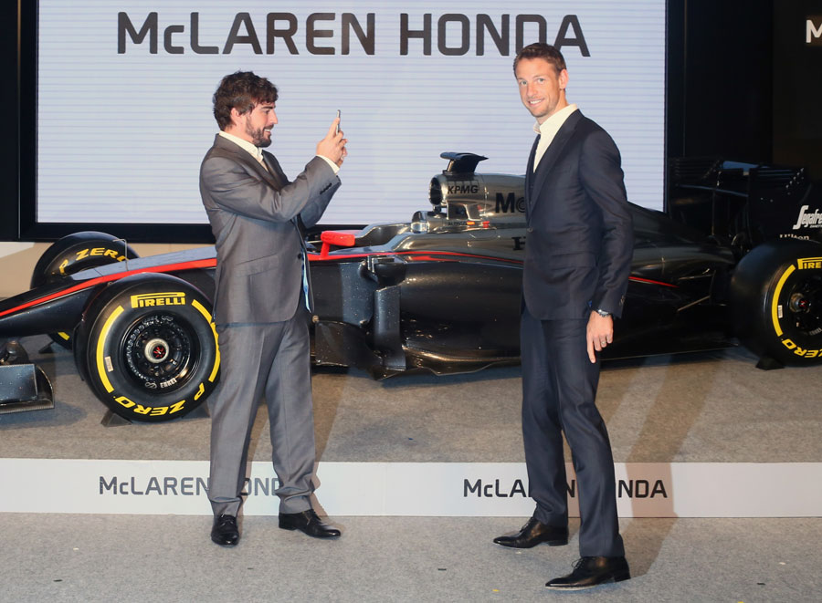 McLaren's Fernando Alonso takes a picture of team-mate Jenson Button at a Honda press conference