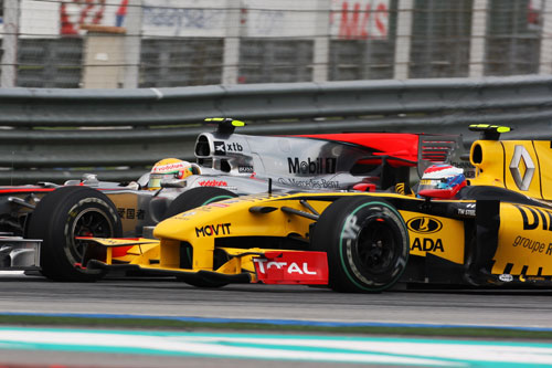 Lewis Hamilton runs wheel-to-wheel with Vitaly Petrov in turn one