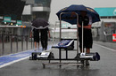 A Williams nose cone is wheeled down a flooded Sepang pit lane
