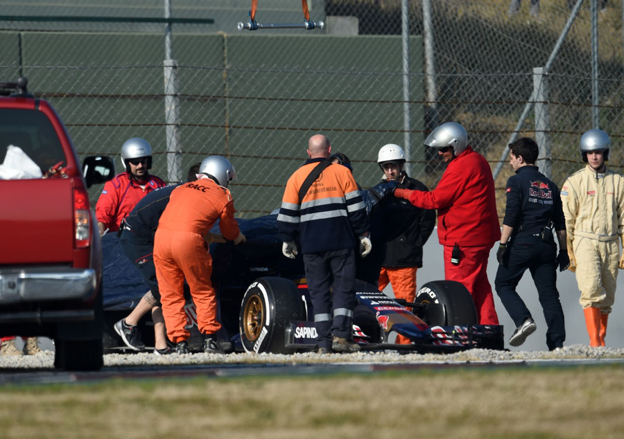 Marshals pull the covers over Carlos Sainz Jr's Toro Rosso after he beached it in the gravel