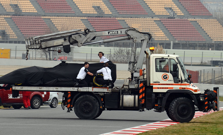 Jenson Button's McLaren is recovered after stopping on track 