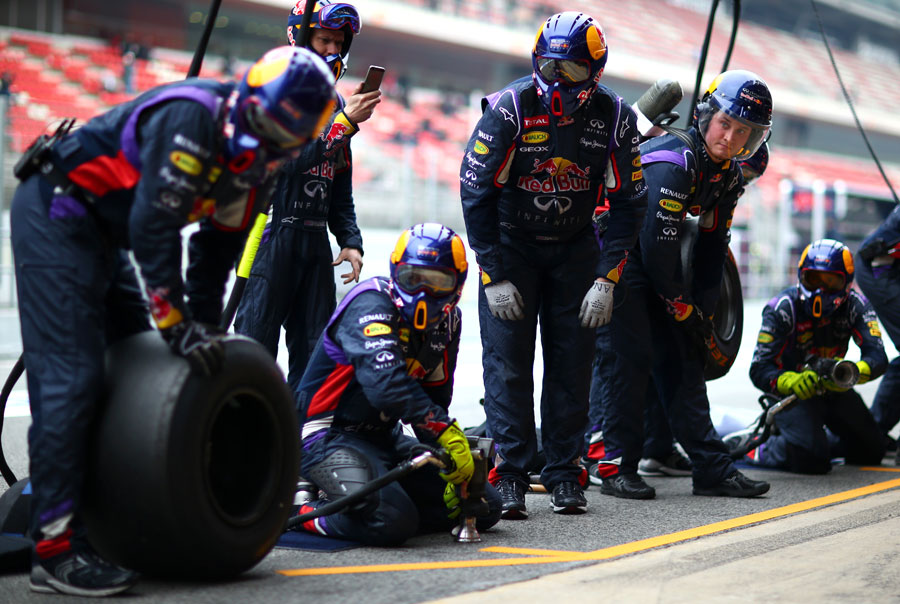 Red Bull mechanics await the arrival of Daniil Kvyat for pit stop practice