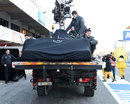 Nico Rosberg's Mercedes returns to the pits on a flatbed truck after an early spin