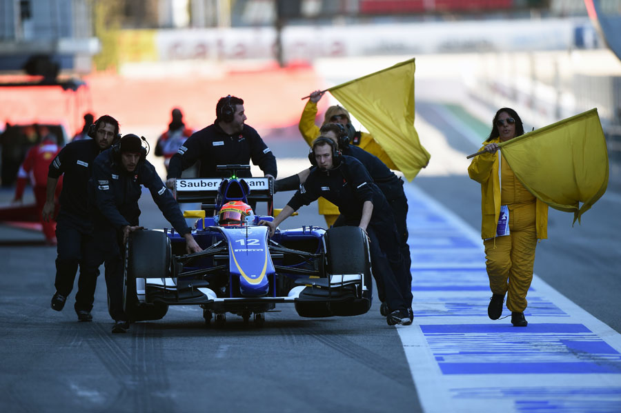 Felipe Nasr's Sauber's is wheeled back to the garage after he stopped at the pit entry