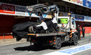 Fernando Alonso's McLaren returns to the pits after he crashed on the final morning of the test