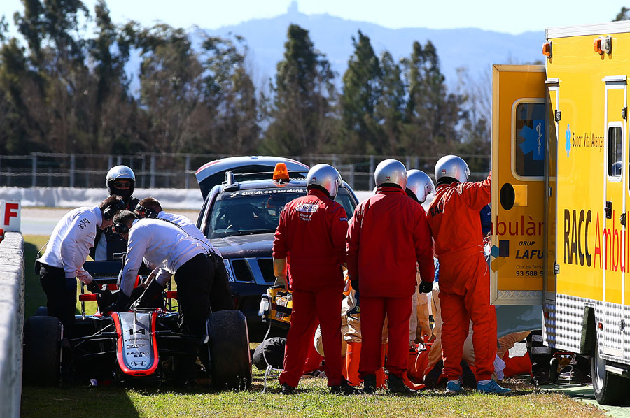 Fernando Alonso is loaded into the ambulance after crashing his McLaren