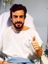 Fernando Alonso gives his supporters the thumbs up from hospital