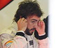 Fernando Alonso adjusts his headphones in the McLaren garage