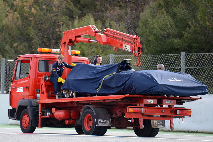 Carlos Sainz's Toro Rosso is returned to the pits on a flatbed truck