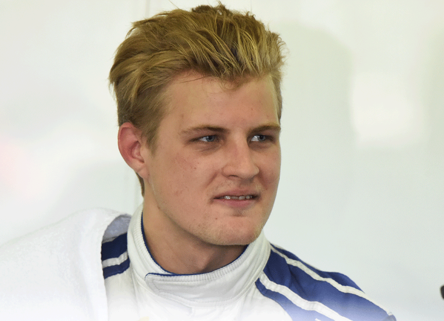Marcus Ericsson speaks to a mechanic in the Sauber garage
