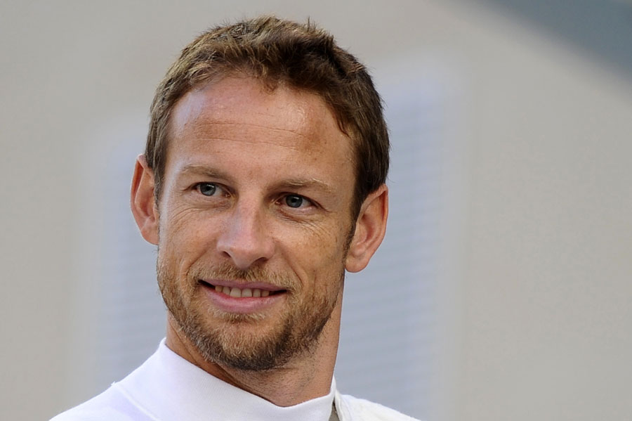 McLaren's Jenson Button looks on in the paddock