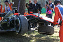 Kevin Magnussen's wrecked McLaren is picked up by marshals after his FP2 crash