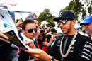 Lewis Hamilton signs autographs for fans on his arrival at the track
