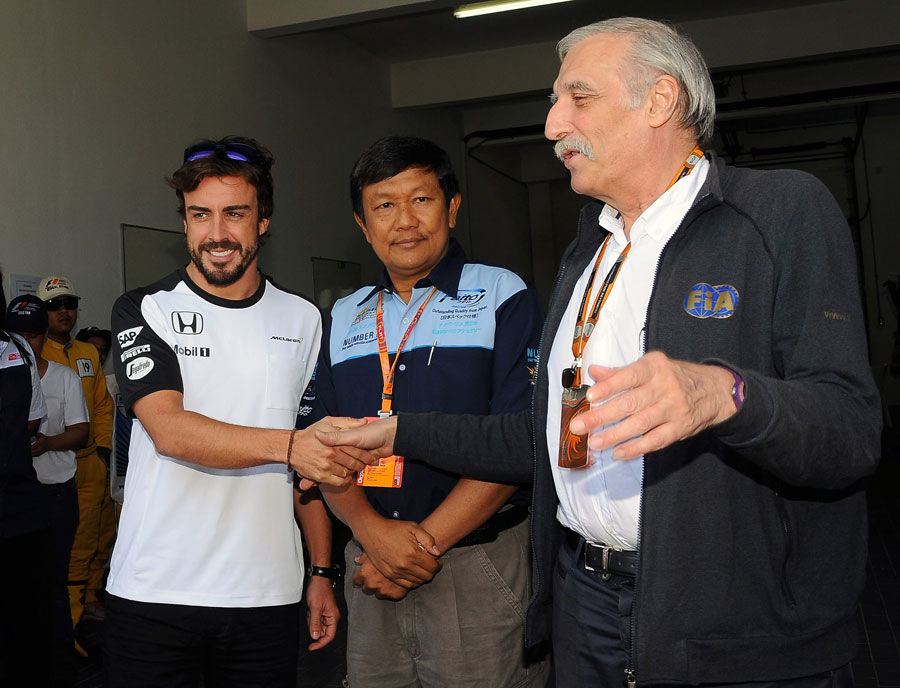 Fernando Alonso shakes hands with the FIA medical delegate Jean-Charles Piette after being declared fit to race in Malaysia