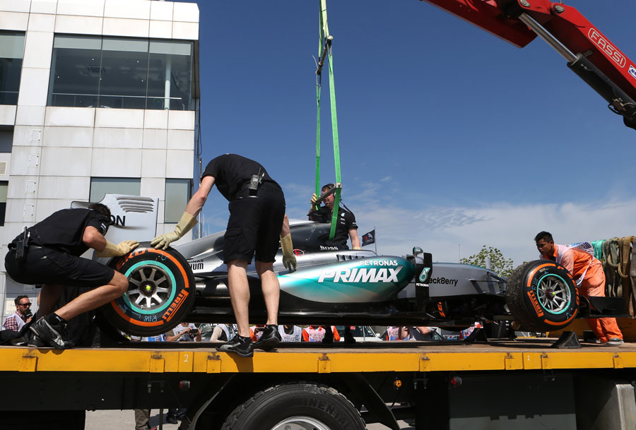 Lewis Hamilton's Mercedes returns on a flatbed truck after a technical issue on track
