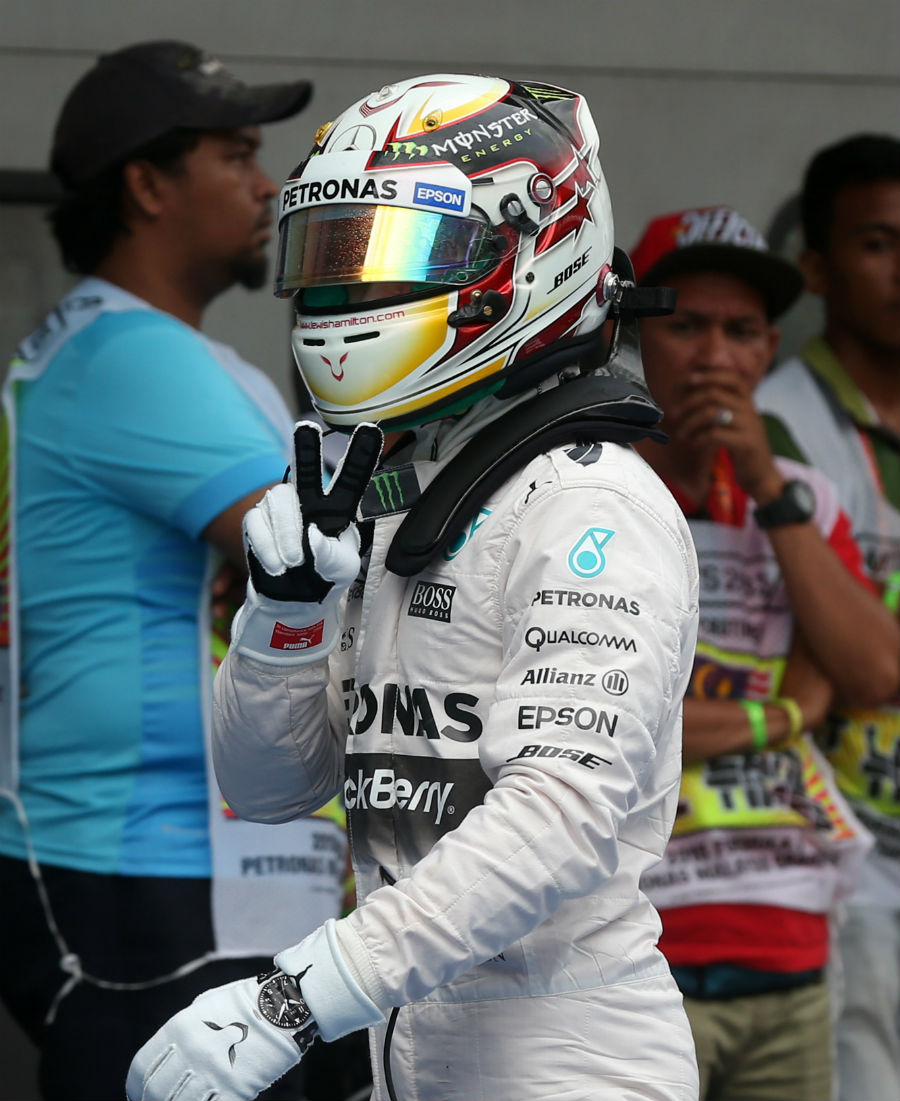 Lewis Hamilton gestures to the cameras after clinching pole