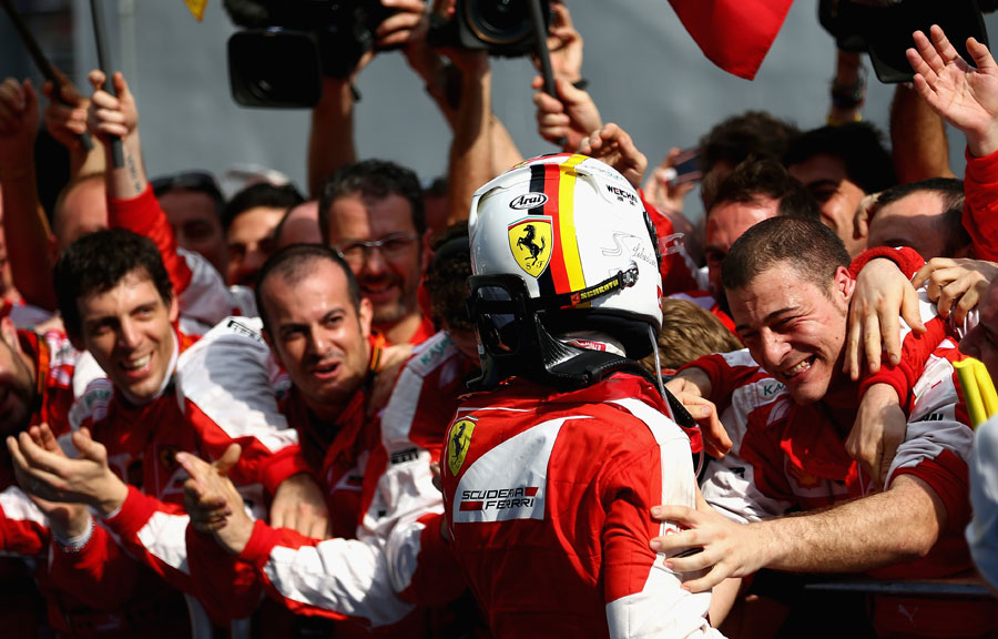 Sebastian Vettel celebrates with the Ferrari team