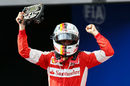 Race winner Sebastian Vettel lifts the steering wheel of his Ferrari in parc ferme
