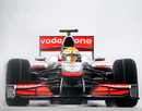Lewis Hamilton bursts through the spray in Sepang