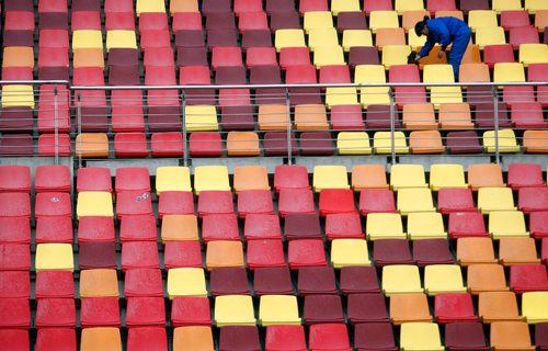 A worker cleans seats ahead of the Chinese Grand Prix