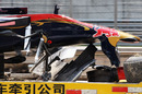 The damaged Torro Rosso of Sebastien Buemi is brought back to his team garage