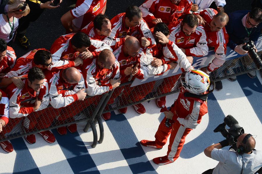 Sebastian Vettel celebrates with Ferrari members in parc ferme