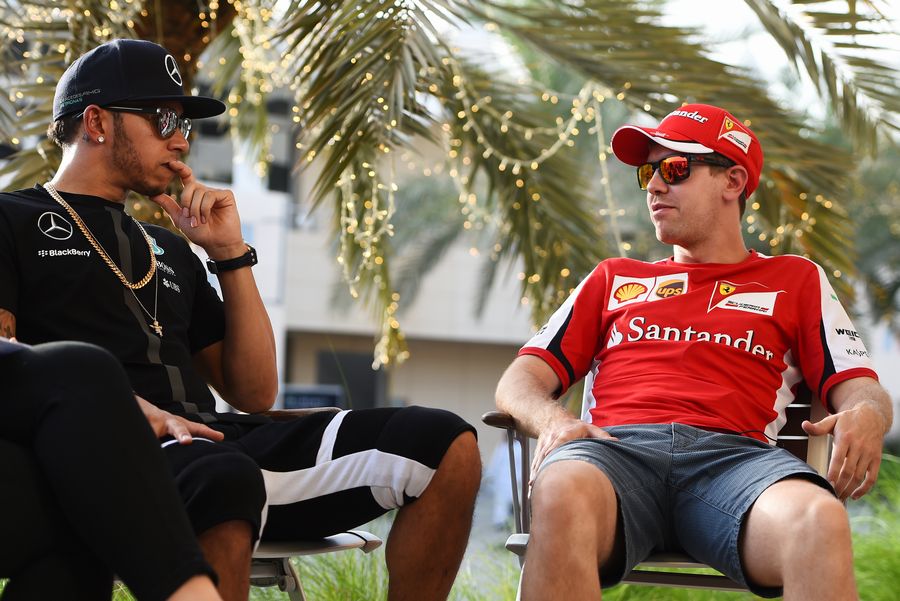 Lewis Hamilton and Sebastian Vettel chat and share a joke in the paddock