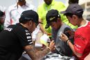 Lewis Hamilton signs an autograph for a young fan