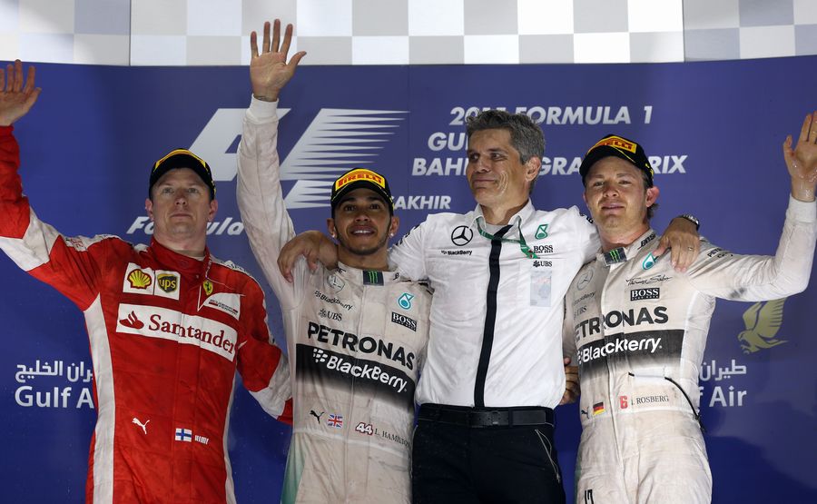 Lewis Hamilton, Kimi Raikkonen and Nico Rosberg acknowledge the crowd during a sombre podium ceremony