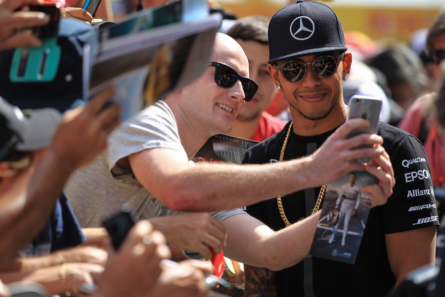 Lewis Hamilton poses for a photo with a fan