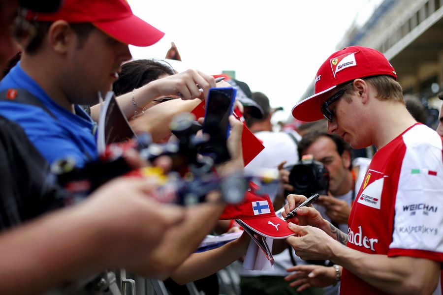 Kimi Raikkonen signs an autograph for a fan