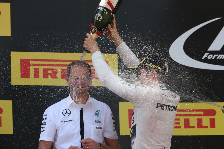 Race winner Nico Rosberg celebrates with Engineer Tony Ross on the podium